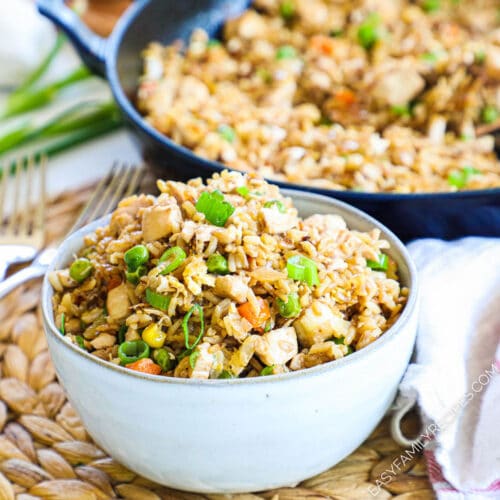 Chicken fried rice in a bowl with skillet in background
