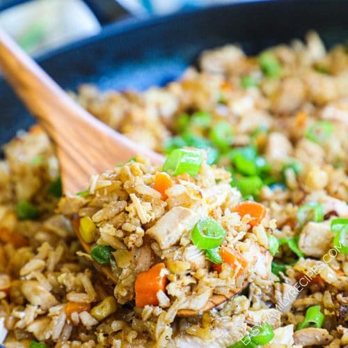 Skillet full of easy Chicken fried rice with a spoon in it.
