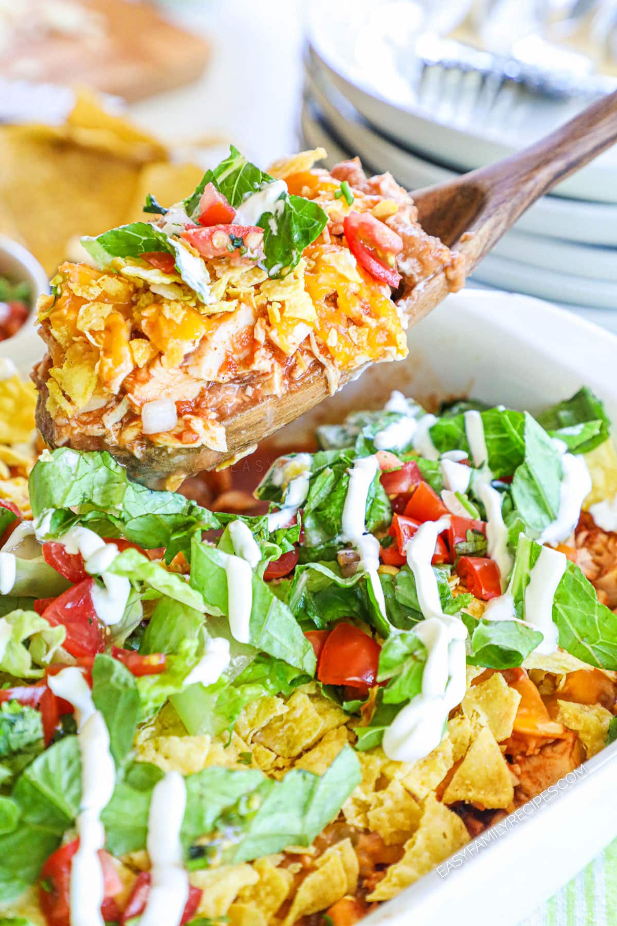 Scooping baked chicken taco casserole from casserole dish
