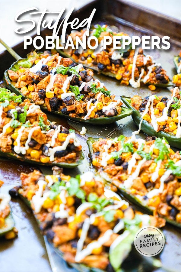 Poblano Peppers stuffed with chicken and drizzled with sour cream on a baking sheet