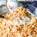 Spoonful of creamy chicken and rice casserole lifting from casserole dish.