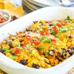 Baked Sante Fe Chicken in a casserole dish covered in corn, black beans, cheese and sauce