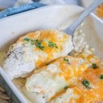 Lifting chicken breast with cheese topping out of casserole dish