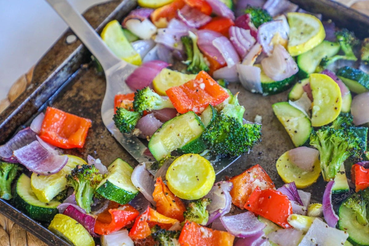 Roasted Vegetables being lifted from pan after baking