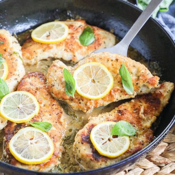 Lifting chicken breast from lemon butter sauce with a spatula