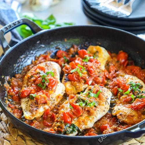 Chicken in pomodoro sauce in a skillet garnished with fresh basil.