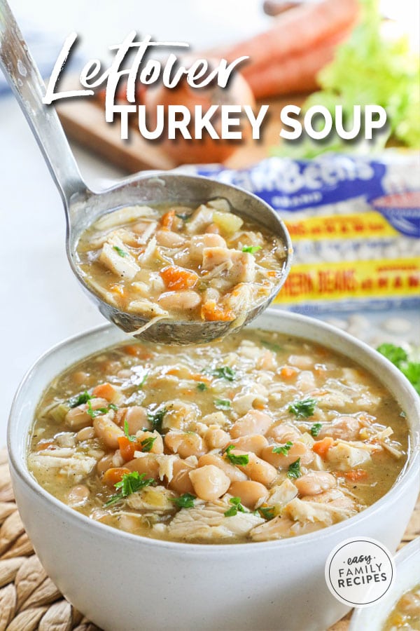 Ladling a big scoop of leftover turkey soup into s bowl