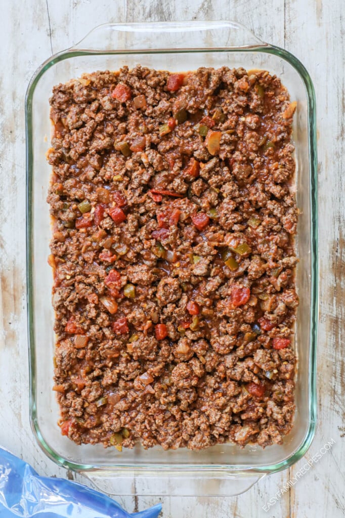How to make Taco Casserole Step 2: Layer ground beef taco meat over the beans.