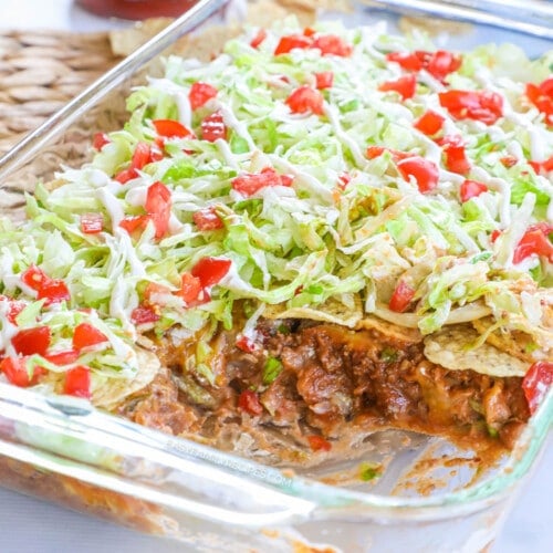 Taco Casserole with ground beef topped with lettuce tomato and sour cream