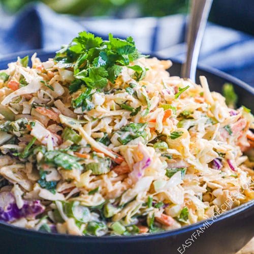 Bowl of homemade asian coleslaw with sriracha and lime and garnished with cilantro