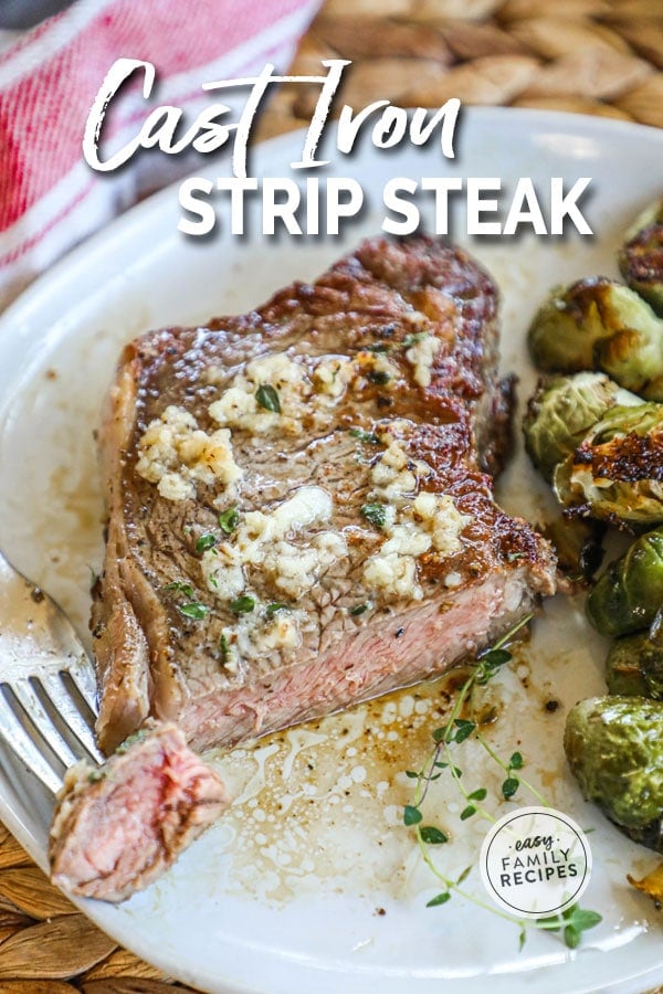 Strip steak prepared in a cast iron skillet and served on a plate with brussels sprouts