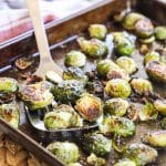 Oven Brussels Sprouts slightly charred being lifted with a spatula