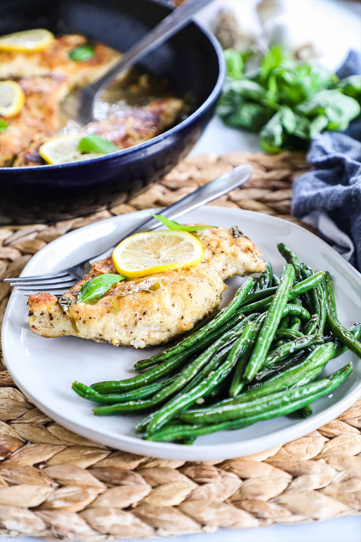 green beans on a plate next to chicken breast