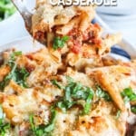Big spoonful of Chicken parmesan casserole being lifted from casserole dish.