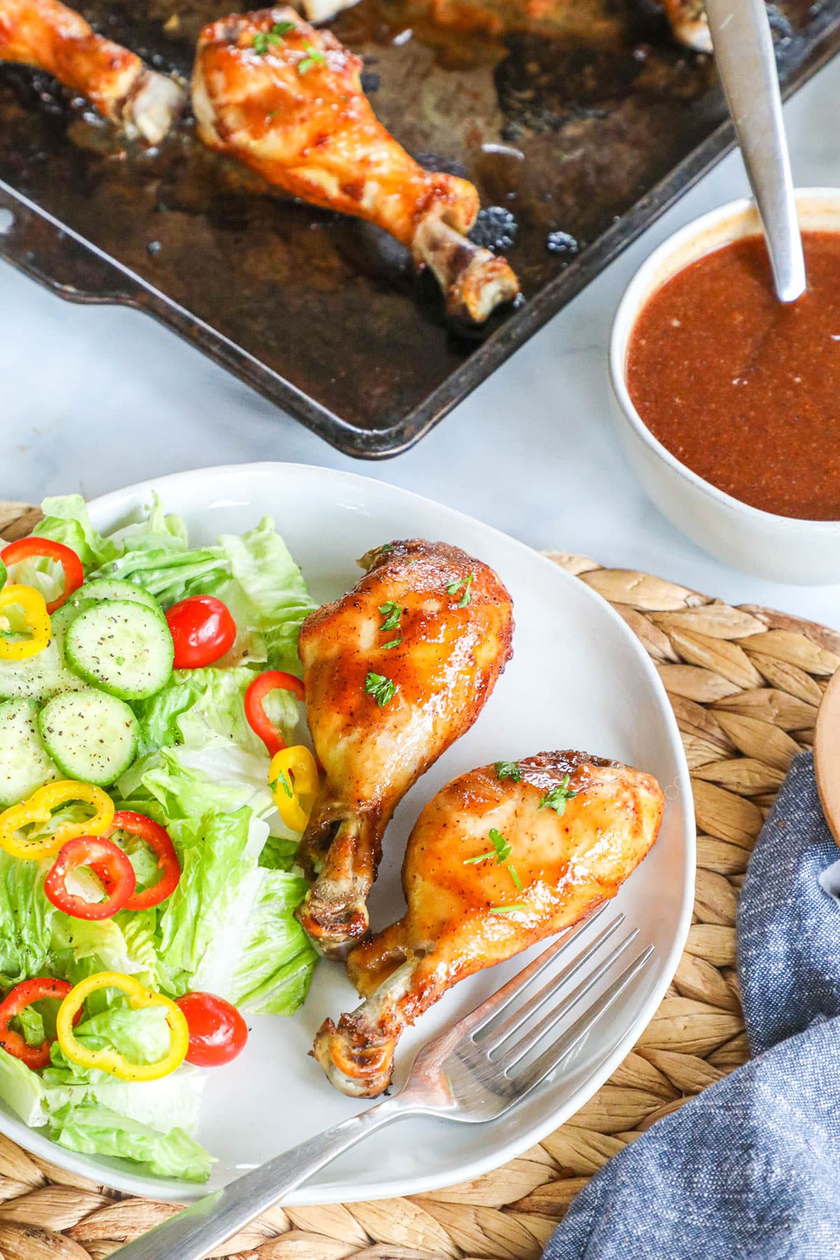 Overhead view of BBQ Chicken Drumsticks on a plate served with salad for dinner.