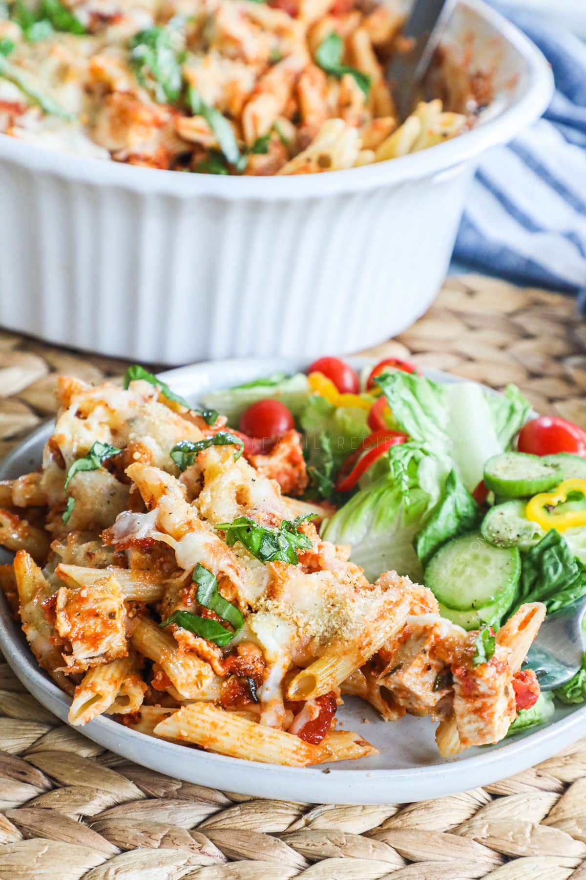 Chicken Parmesan Casserole served with salad on a plate.
