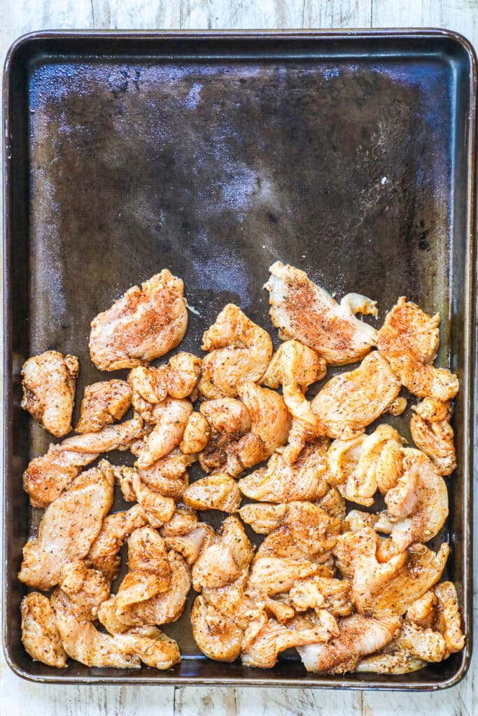 How to make sheet pan chicken fajitas step 1: Thinly slice chicken breast and season it with fajita seasoning.