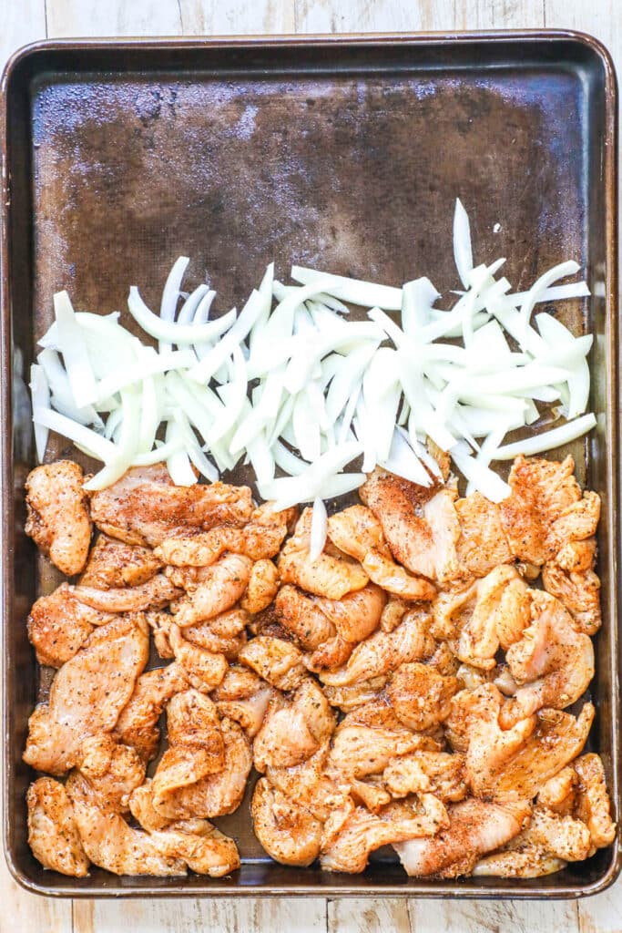 How to make sheet pan chicken fajitas step 2: Add the chicken breast and thinly sliced onion to a large sheet pan.