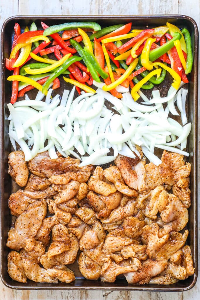 How to make sheet pan chicken fajitas step 3: thinly slice green, red and yellow bell pepper and add to the baking sheet.