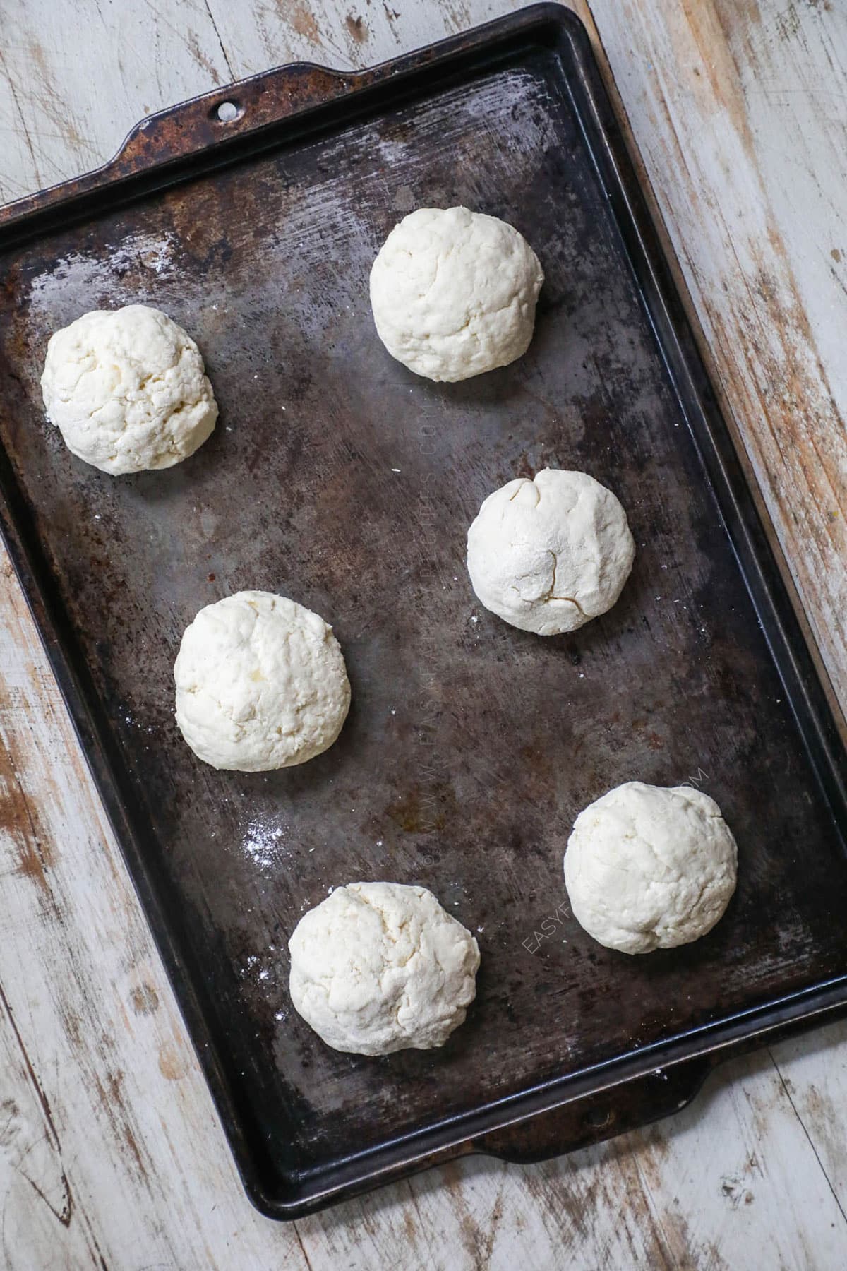 Step 3 - Divide the dough into 6 equal parts. Flour your hands then roll each into a ball and place it on a baking sheet.