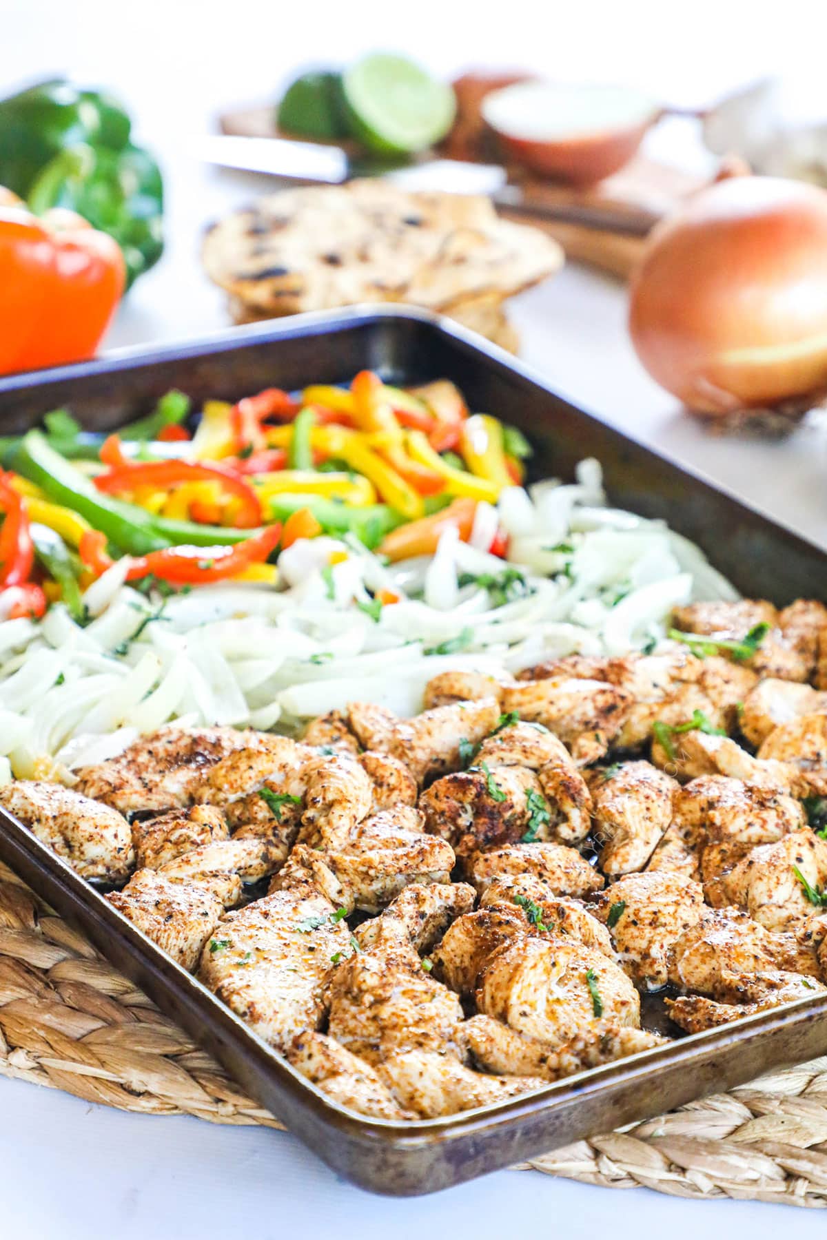 Baked Chicken Fajitas on a sheet pan with bell peppers and onions.