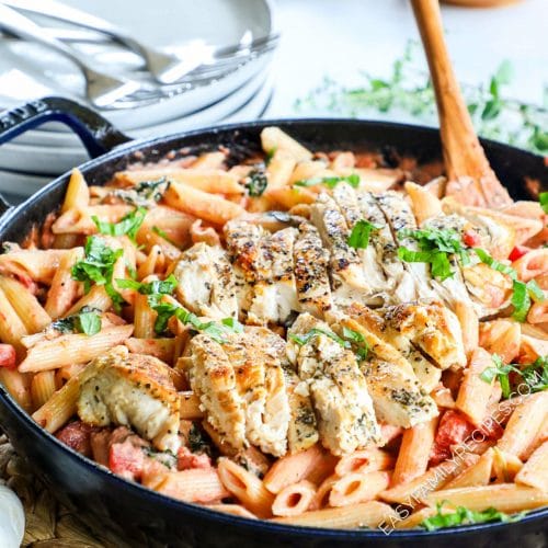 Large skillet with Italian Chicken Pasta garnished with basil