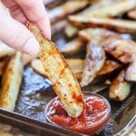 Dipping Potato Wedge baked french fries into ketchup