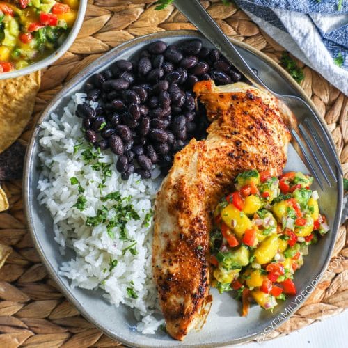 Chicken breast topped with mango salsa plated with cilantro lime rice and black beans