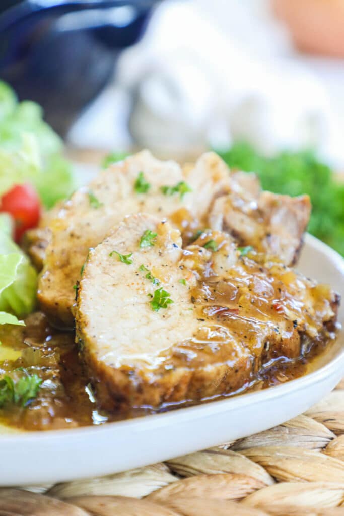 Plated pork tenderloin and gravy with a green salad