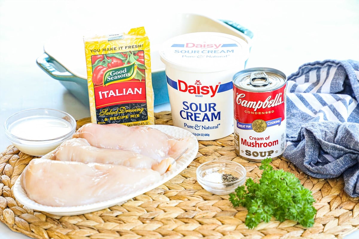 Ingredients for making cream of mushroom chicken casserole with chicken breast, Campbell's cream of mushroom soup, sour cream, and seasonings.