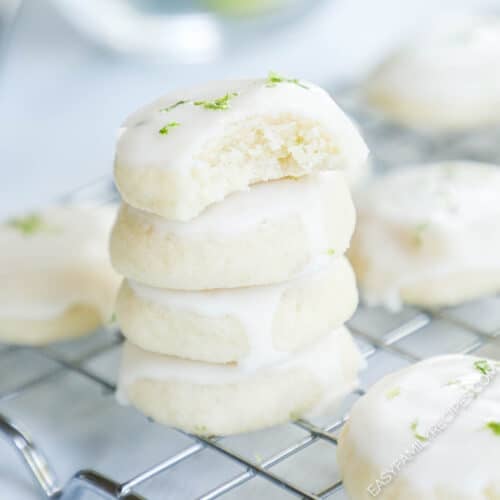 Bite sized key lime cookies stacked on a cooling rack.