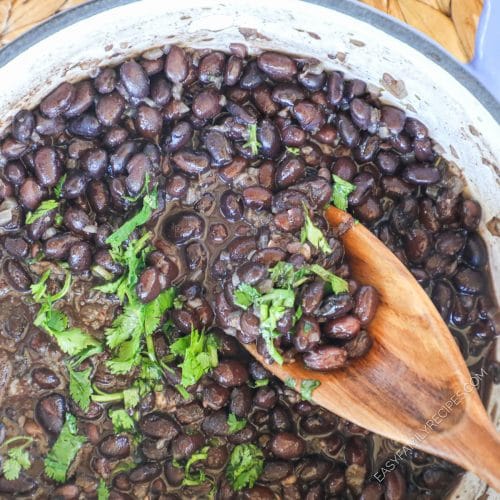 Mexican Canned black beans cooked in a pot and garnished with cilantro
