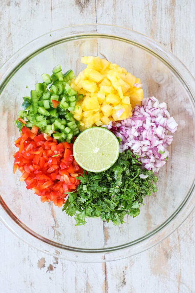 Step 2 for pineapple salsa chicken - Finely dice the pineapple, bell pepper, jalapeno, onion and cilantro. Then mix together