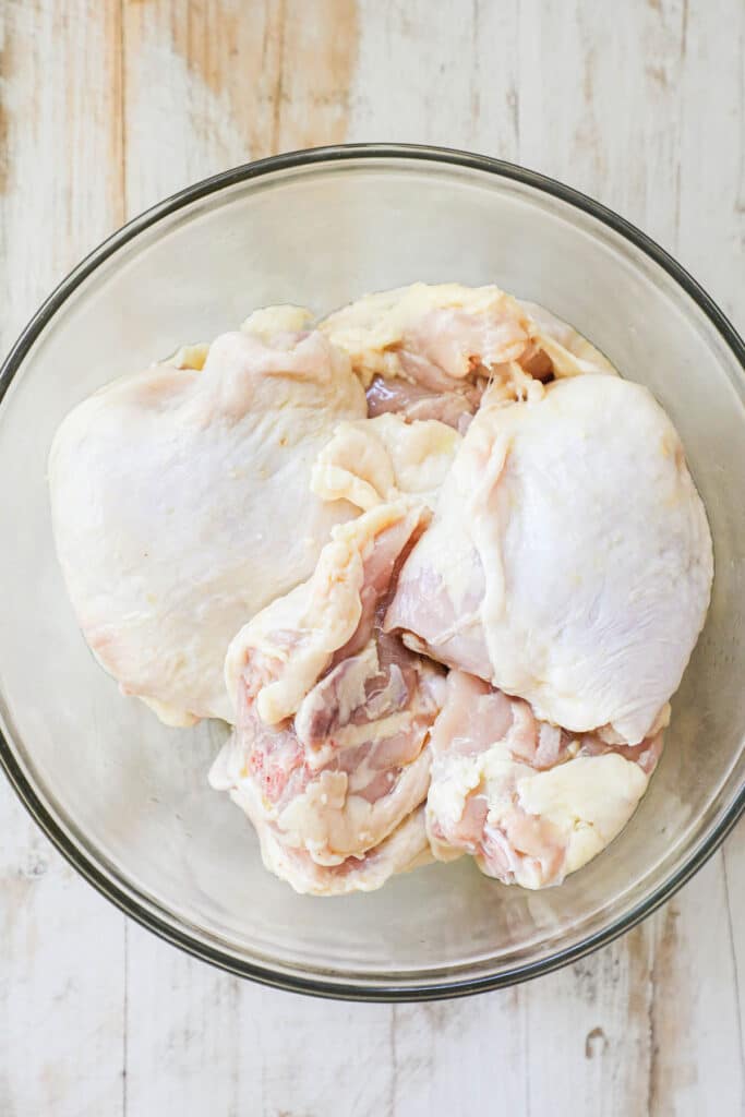 How to make ranch baked chicken thighs step 1: place chicken thighs in a bowl and drizzle with olive oil.