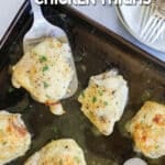 Spatula lifting a ranch chicken thigh off the baking sheet.