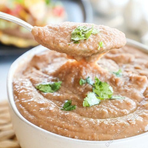 Refried beans made in the crockpot in a serving bowl garnished with cilantro