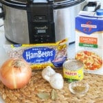 Ingredients for making homemade refried beans including pinto beans, onion, garlic, green chiles adn chicken broth.