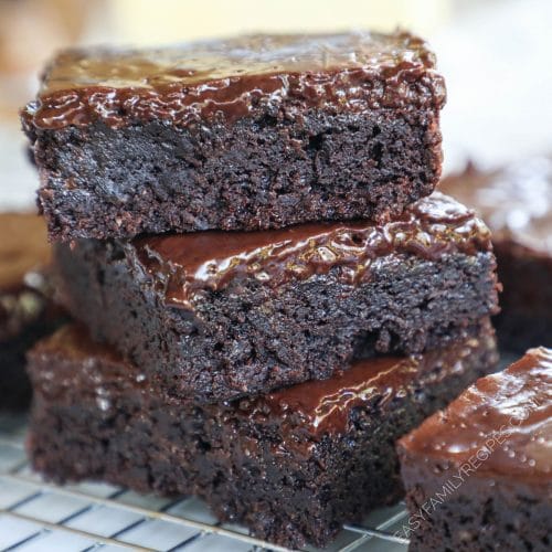 Stack of dark fudge brownies with frosting