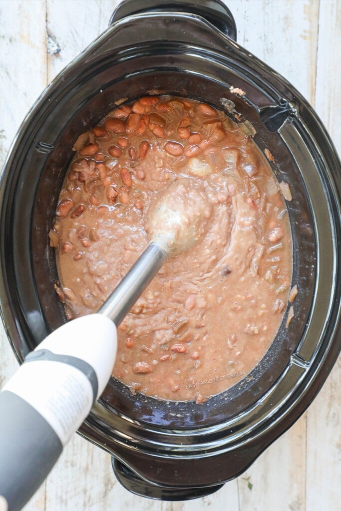 How to make slow cooker refried beans step 3: remove bay leaves and blend with a stick blender until desired consistency has been reached.