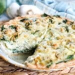 Spinach Artichoke Quiche Recipe made with a frozen pie crust in a tin pie pan.