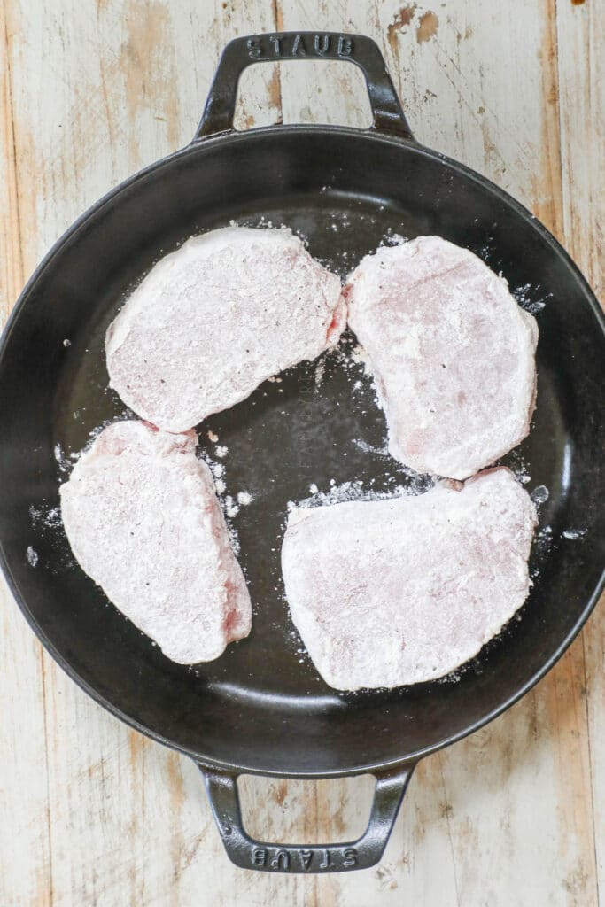 How to make Tuscan Pork Chops step 1: Coat the pork chops in flour mixture and then fry on each side in cast iron skillet.