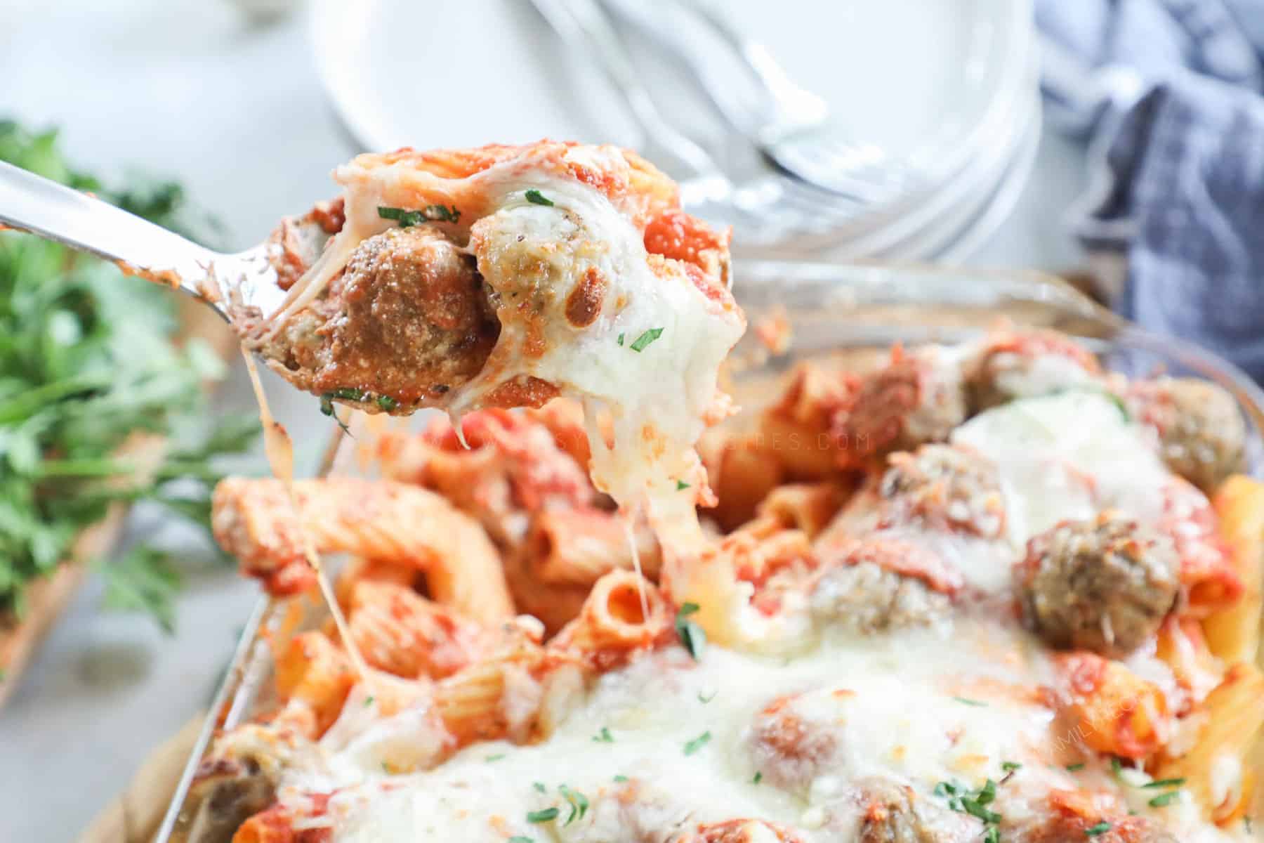 Meatball Pasta Casserole recipe prepared and being lifted from the casserole dish with a spoon.