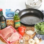 Ingredients for making Tuscan pork chops including boneless pork chops, flour, garlic, balsamic vinegar, chicken broth, tomatoes, and spinach.