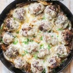 French Onion Meatballs covered in cheese in a skillet