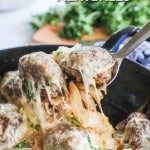 Lifting a serving of French Onion Meatballs out of the pan