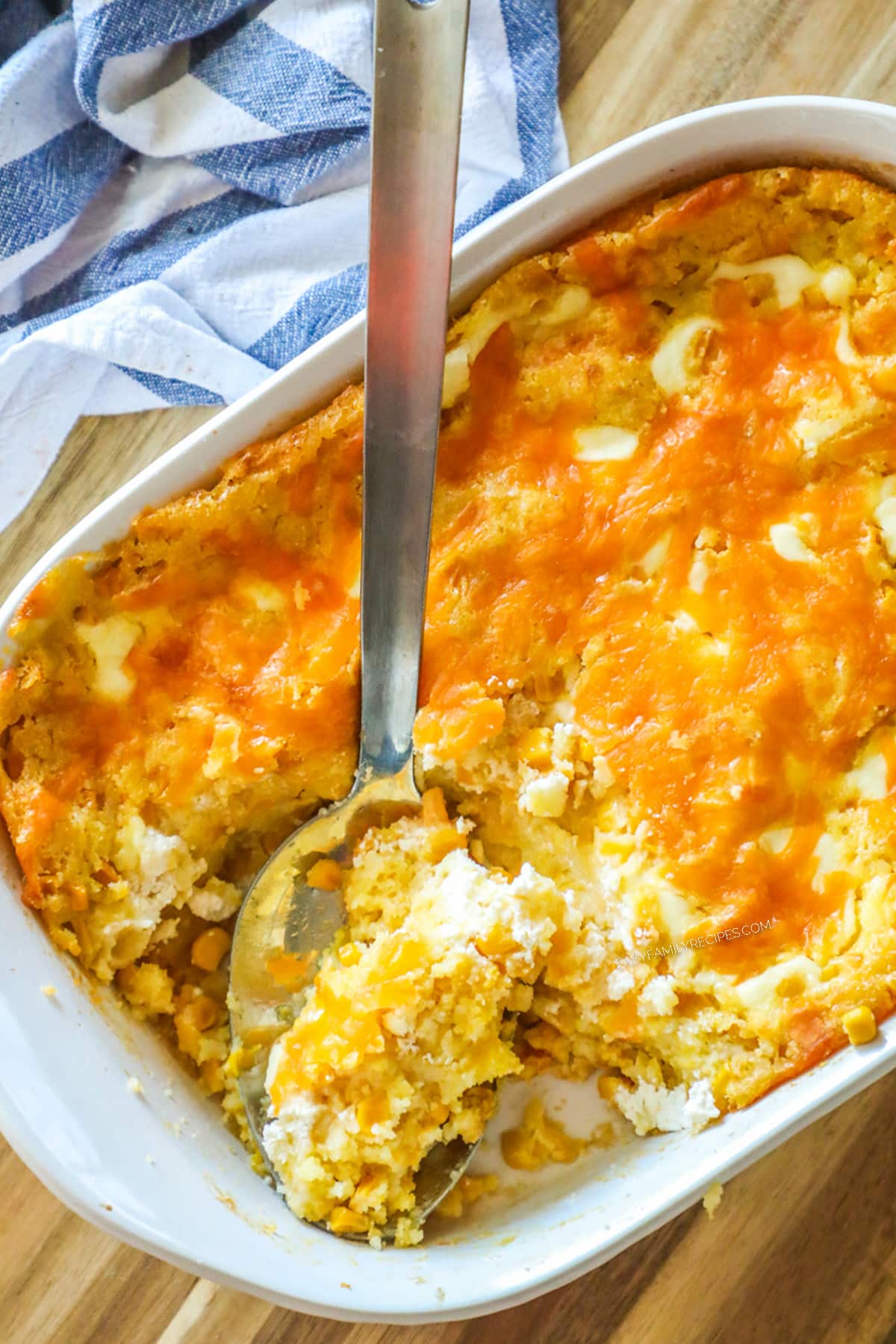 Overhead photo of cheesy corn casserole being scooped to serve.