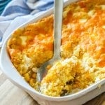 Jiffy Corn Casserole topped with cheese getting served out of casserole dish