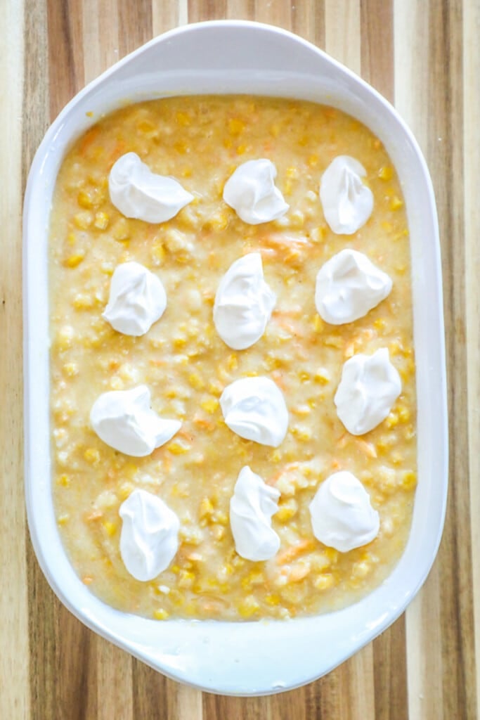 How to make Jiffy Corn Casserole Step 4: dollop sour cream on top of the corn casserole evenly.