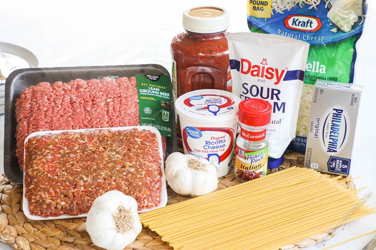 Baked Million Dollar Spaghetti ingredients including spaghetti, ground beef, Italian sausage, ricotta cheese, cream cheese, mozzarella cheese, Italian seasoning, and spaghetti sauce