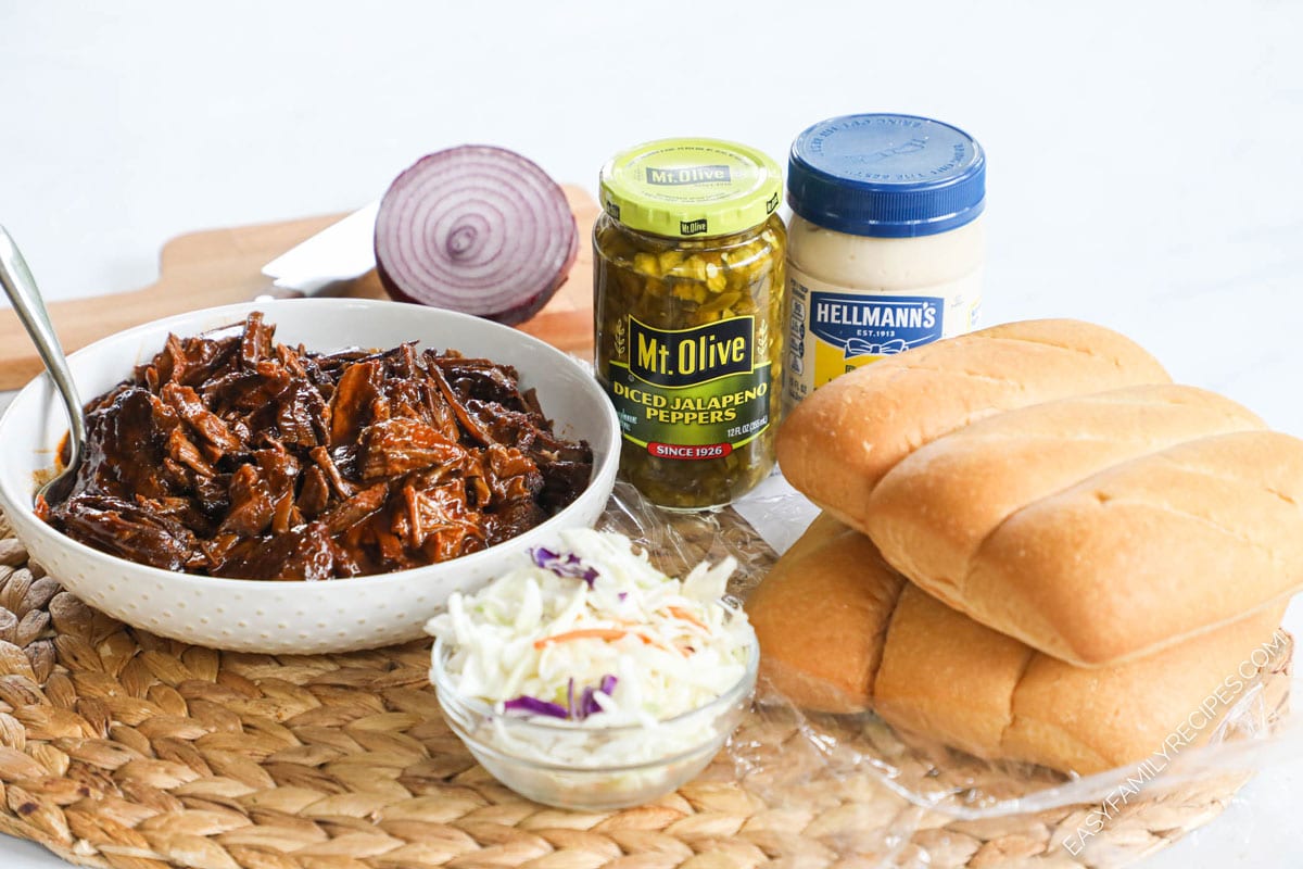 Ingredients for Leftover Brisket Sandwich including chopped brisket, sub rolls, coleslaw, mayonnaise, onion, jalapenos